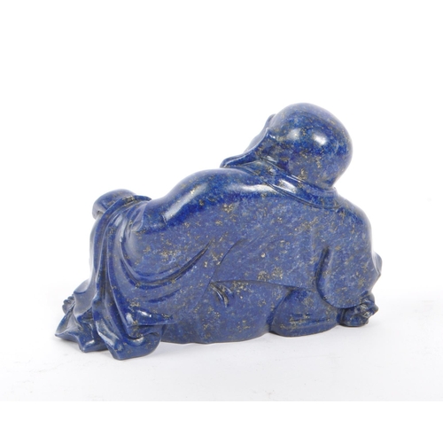 376 - A 20th century Chinese lapis lazuli semi precious stone carved buddha. The buddha in a seated laid b... 