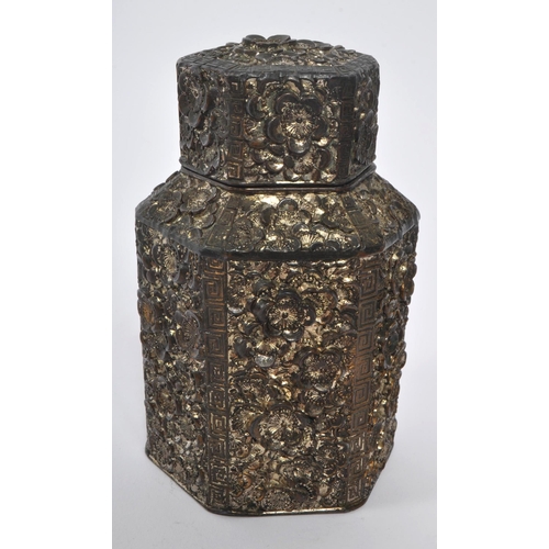 383 - A 19th century Chinese embossed white metal tea caddy. Having a hexagonal form lid with embossed flo... 