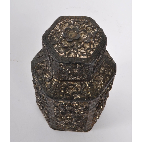 383 - A 19th century Chinese embossed white metal tea caddy. Having a hexagonal form lid with embossed flo... 