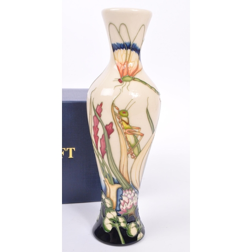 386 - Moorcroft - A china Moorcroft Pottery slim vase in the ' Grasshopper ' pattern designed by Philip Ri... 