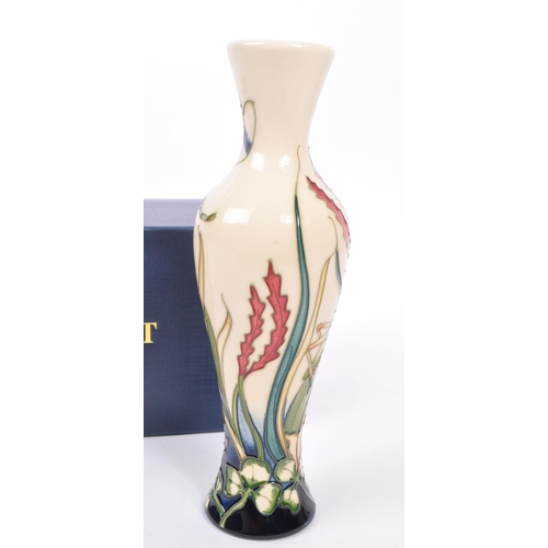 386 - Moorcroft - A china Moorcroft Pottery slim vase in the ' Grasshopper ' pattern designed by Philip Ri... 