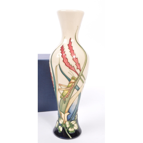 386 - Moorcroft - A china Moorcroft Pottery slim vase in the ' Grasshopper ' pattern designed by Philip Ri... 