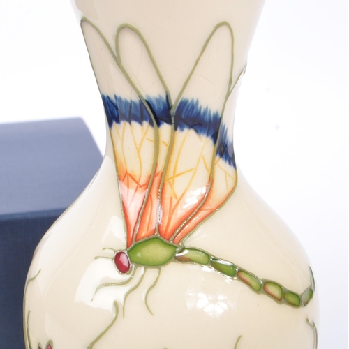 386 - Moorcroft - A china Moorcroft Pottery slim vase in the ' Grasshopper ' pattern designed by Philip Ri... 