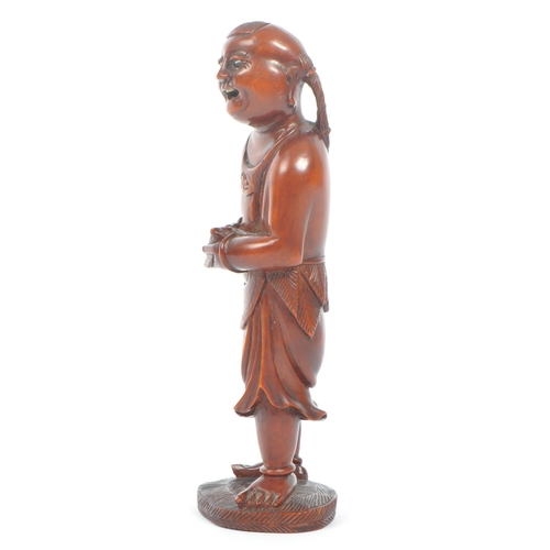 391 - A Japanese early 20th century hand carved wood figure of Liu Hai. Standing positing with bone teeth ... 