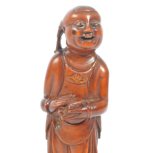 391 - A Japanese early 20th century hand carved wood figure of Liu Hai. Standing positing with bone teeth ... 