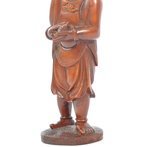 391 - A Japanese early 20th century hand carved wood figure of Liu Hai. Standing positing with bone teeth ... 