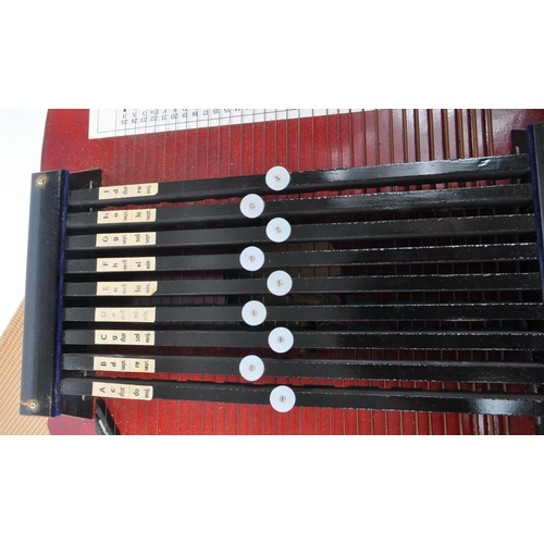 427 - A 20th Century vintage nine chord bar autoharp in red and black with picture of scale to bottom. In ... 