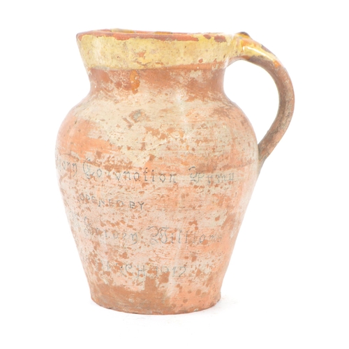 46 - A early 20th century George V clay pottery water jug. Commemorative water jug with handle and round ... 