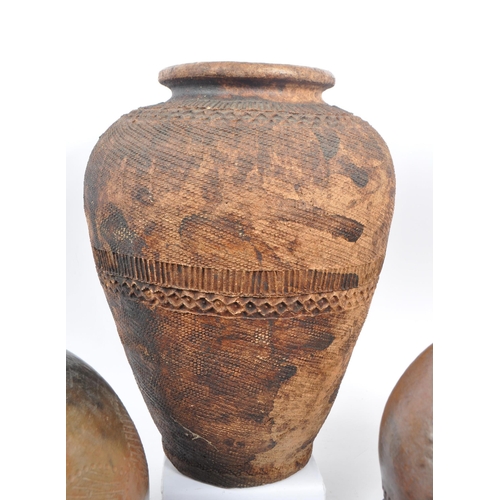 67 - A 20th century Nigerian Nupe water storage pot, alongside other decorative tribal pots. The collecti... 