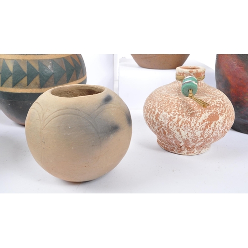 76 - A large collection of ceramic tribal folk art bowls, pots, and vases. The collection to include a va... 