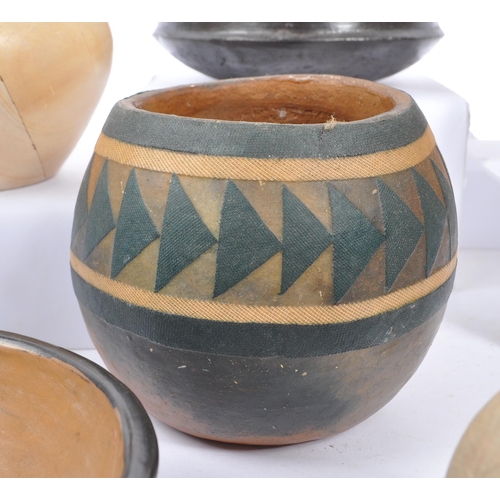 76 - A large collection of ceramic tribal folk art bowls, pots, and vases. The collection to include a va... 