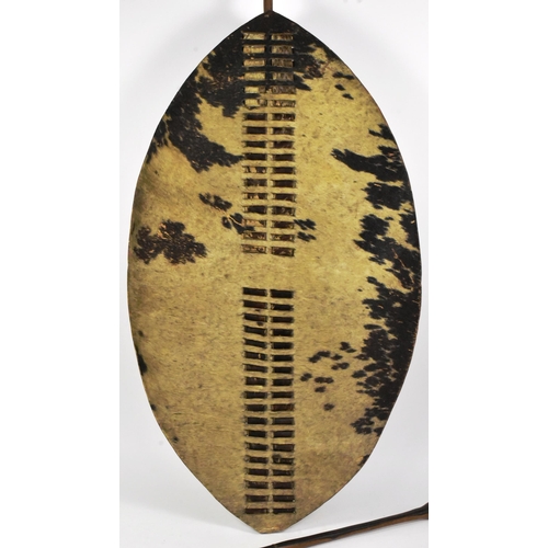 11 - An original Zulu Nguni cowhide shield (Isihlangu) shield together with a Zulu spear. Oval white & br... 