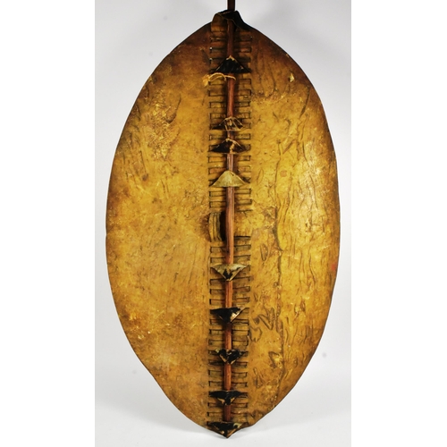 11 - An original Zulu Nguni cowhide shield (Isihlangu) shield together with a Zulu spear. Oval white & br... 