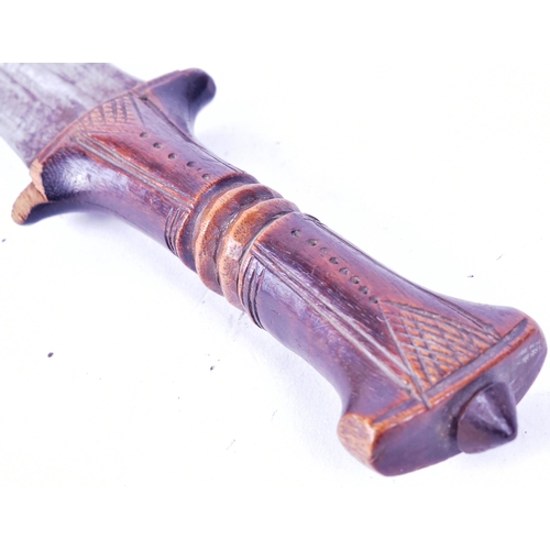 186 - A West African Hausa People tribal dagger. Carved wooden grip with a dome shaped metal finial and th... 