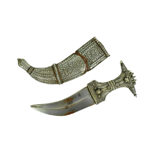 31 - An early 20th Century Saudi Arabian Jambiya / Khanjar dagger. Ornate hilt with applied silver orname... 