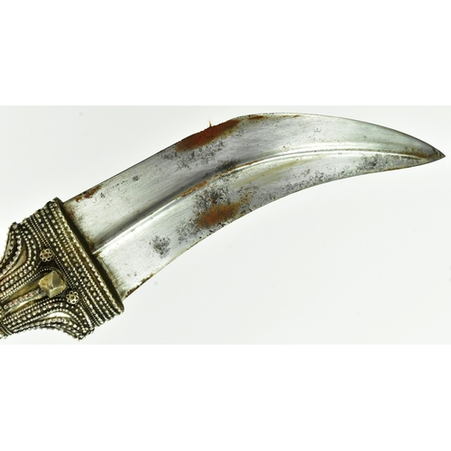 31 - An early 20th Century Saudi Arabian Jambiya / Khanjar dagger. Ornate hilt with applied silver orname... 