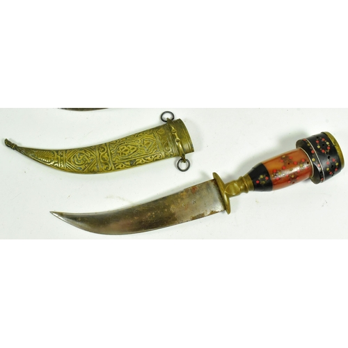 318 - A pair of Syrian Jambiya daggers with brass floral motif pommels, layered man made grips inlaid with... 