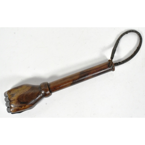 36 - A vintage hardwood truncheon with the pommel carved in the form of a fist. The shaft with a leather ... 