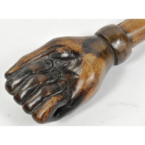 36 - A vintage hardwood truncheon with the pommel carved in the form of a fist. The shaft with a leather ... 