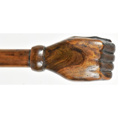 36 - A vintage hardwood truncheon with the pommel carved in the form of a fist. The shaft with a leather ... 