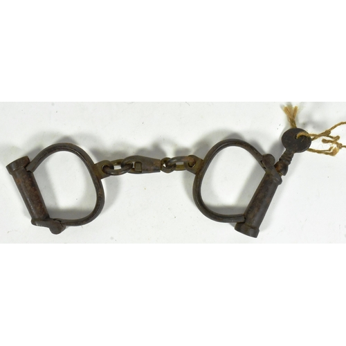 367 - A pair of 19th Century Victorian Police handcuff shackles with key. Stamped Hiatt Best Warranted 388... 