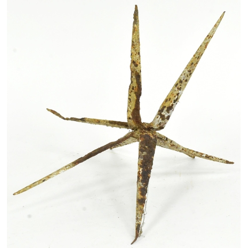 373 - A WWI First World War caltrop / heel trap. Four pieces of metal moulded to form a pointed star. By r... 