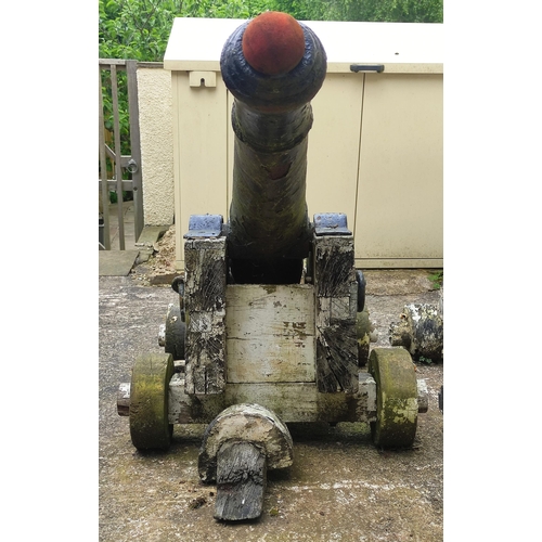 408 - A large period cast cannon barrel set on a wooden base. Tapering cylindrical form with raised ribs d... 