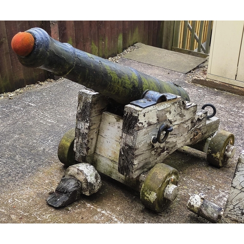 408 - A large period cast cannon barrel set on a wooden base. Tapering cylindrical form with raised ribs d... 