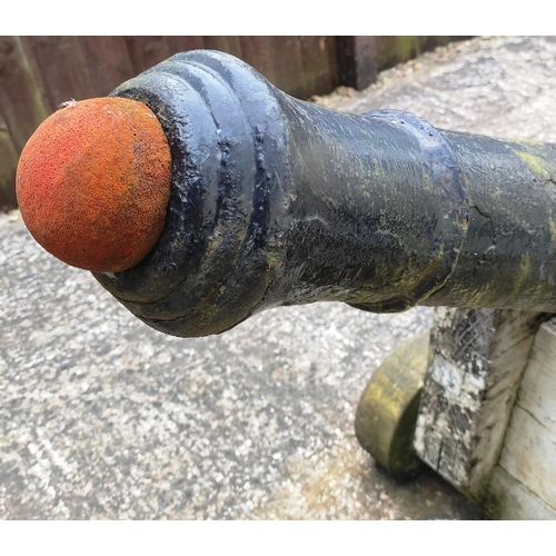 408 - A large period cast cannon barrel set on a wooden base. Tapering cylindrical form with raised ribs d... 