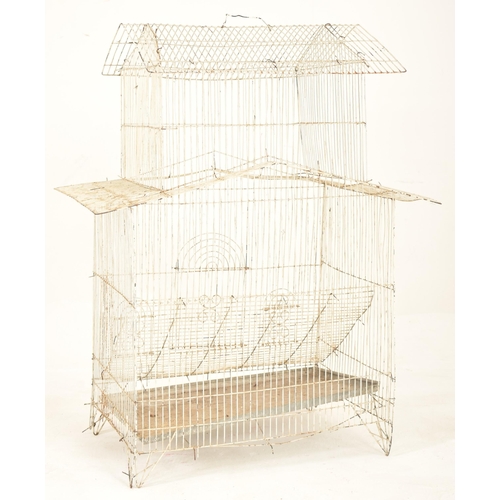 141 - A vintage mid century white painted wire-work birdcage. The bird cage floor standing, featuring two ... 