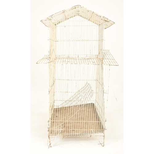 141 - A vintage mid century white painted wire-work birdcage. The bird cage floor standing, featuring two ... 