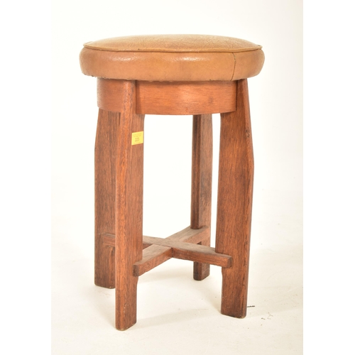 223 - A vintage 20th century Art Deco oak stool. The stool having a circular padded leather upholstered to... 