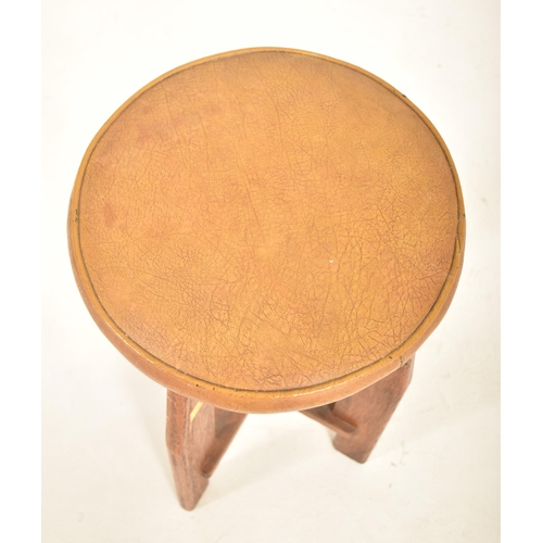 223 - A vintage 20th century Art Deco oak stool. The stool having a circular padded leather upholstered to... 