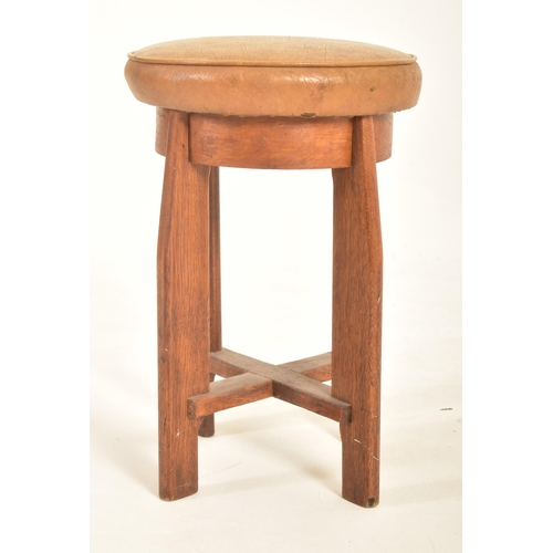 223 - A vintage 20th century Art Deco oak stool. The stool having a circular padded leather upholstered to... 