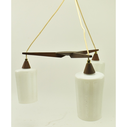 129 - A vintage mid 20th century teak and frosted glass three branch pendent ceiling light. The light feat... 