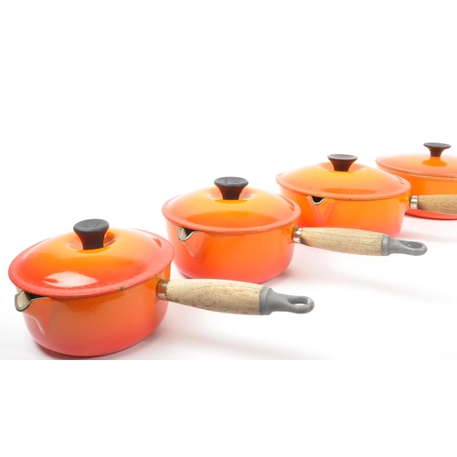 220 - Le Creuset - A collection of four varying sized cast iron Le Creuset saucepans with lids in volcanic... 