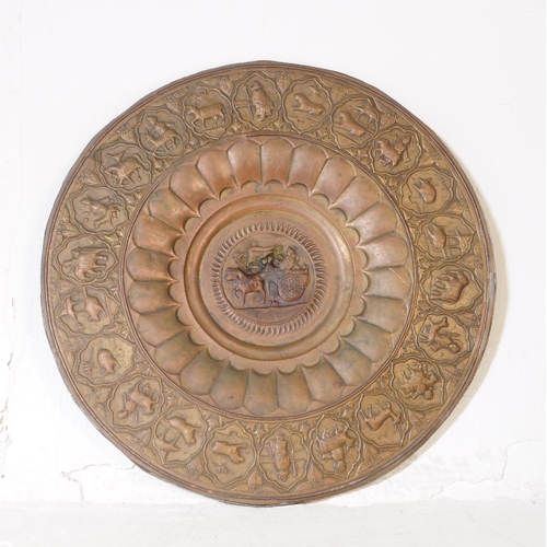 224 - An early 20th century Indian large copper wall plate charger. Featuring a horse and cart motif to ce... 