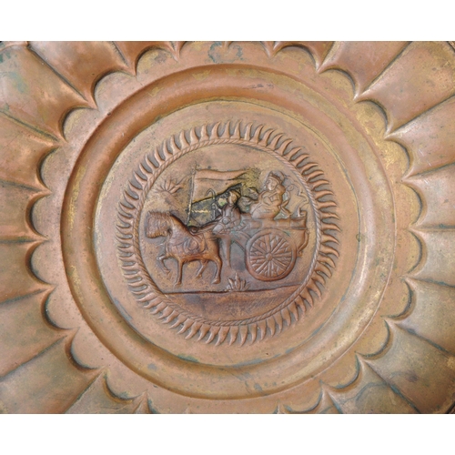 224 - An early 20th century Indian large copper wall plate charger. Featuring a horse and cart motif to ce... 