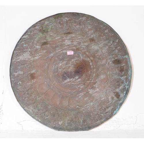 224 - An early 20th century Indian large copper wall plate charger. Featuring a horse and cart motif to ce... 