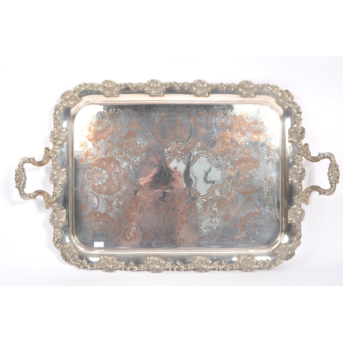 225 - An early 20th Century large silver plated ornate tray having relief foliate design to border and han... 