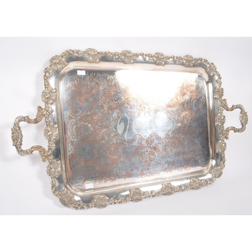 225 - An early 20th Century large silver plated ornate tray having relief foliate design to border and han... 