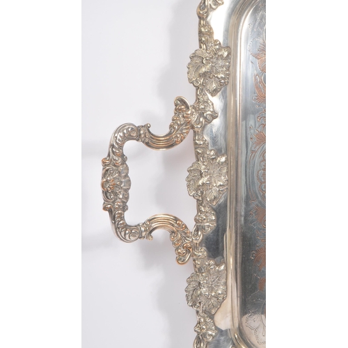 225 - An early 20th Century large silver plated ornate tray having relief foliate design to border and han... 