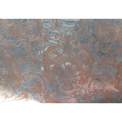 225 - An early 20th Century large silver plated ornate tray having relief foliate design to border and han... 