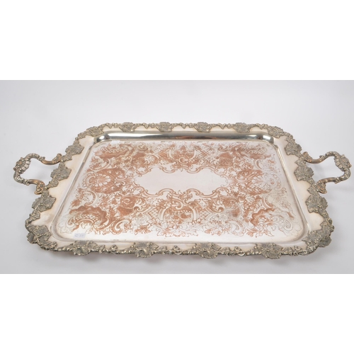 225 - An early 20th Century large silver plated ornate tray having relief foliate design to border and han... 
