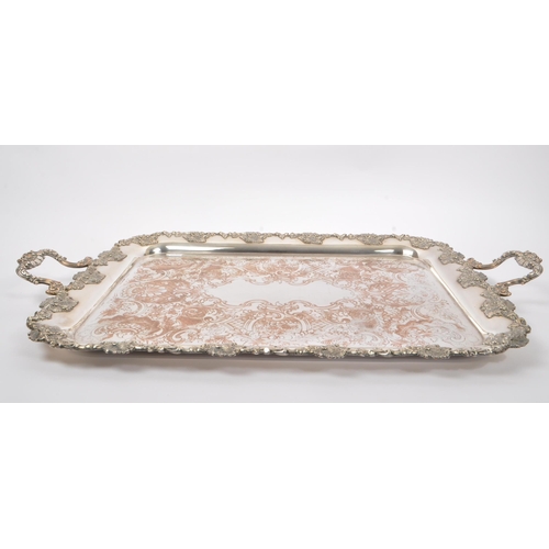 225 - An early 20th Century large silver plated ornate tray having relief foliate design to border and han... 