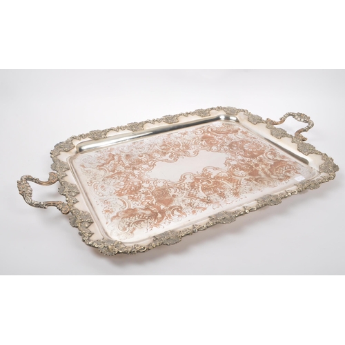 225 - An early 20th Century large silver plated ornate tray having relief foliate design to border and han... 