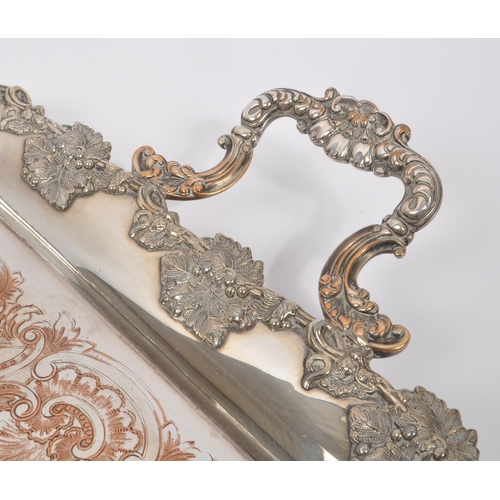 225 - An early 20th Century large silver plated ornate tray having relief foliate design to border and han... 