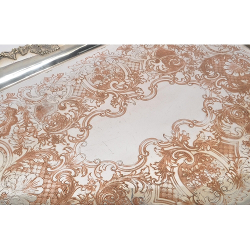 225 - An early 20th Century large silver plated ornate tray having relief foliate design to border and han... 