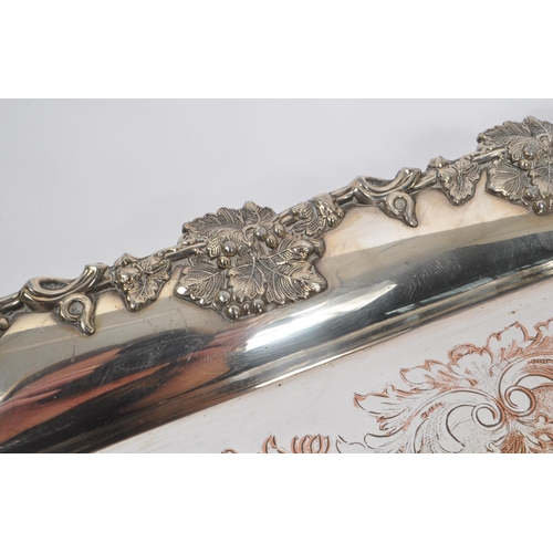 225 - An early 20th Century large silver plated ornate tray having relief foliate design to border and han... 