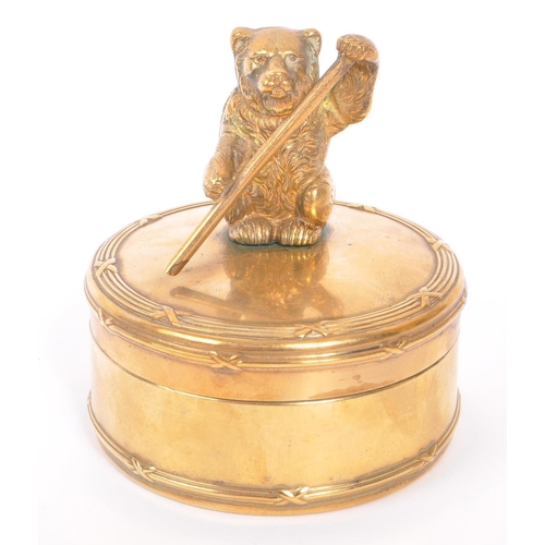232 - An early 20th Century brass circular jewellery box / casket with lidded pot having figure of bear to... 